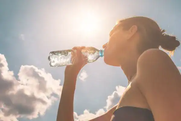 Hydration: The Secret Ingredient for a Toned Stomach and Enhanced Fitness 3 Image of woman drinking water to hydrate Weymouth after run.
