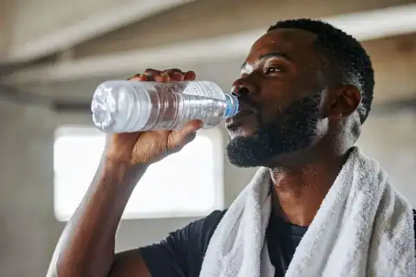 Image of man drinking water to improve hydration Weymouth after work out.